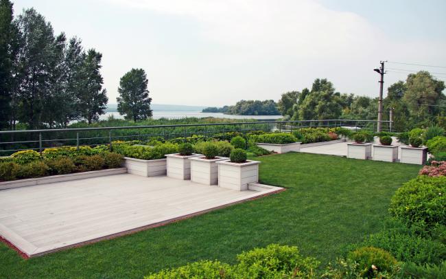 Roof garden with lawn and planters by the riverside